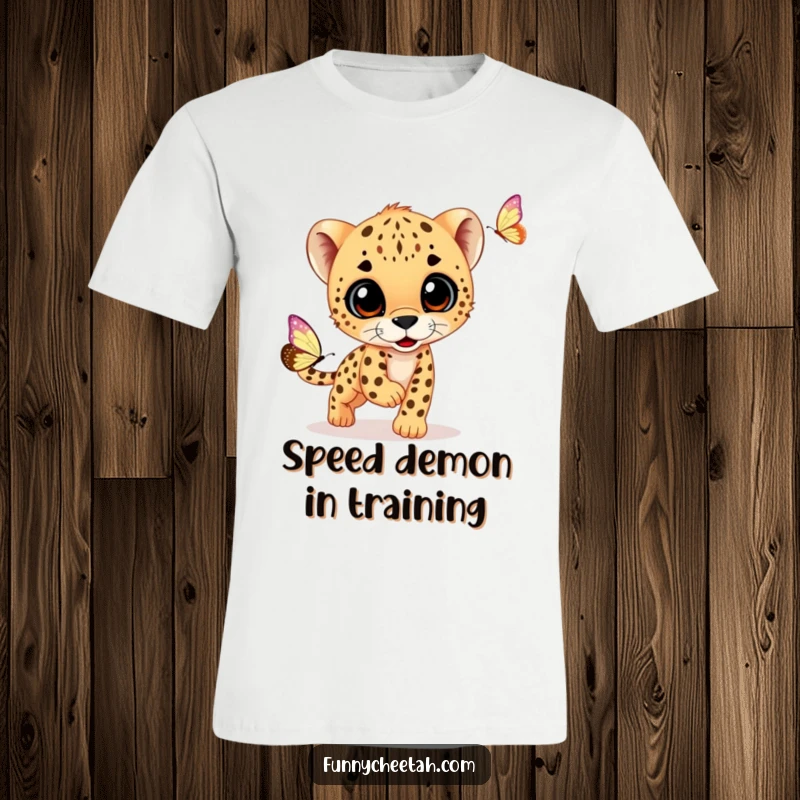 Funny T-shirt showcasing a curious cheetah cub playfully chasing a delicate butterfly, embodying innocent fun and wild charm for wearers.