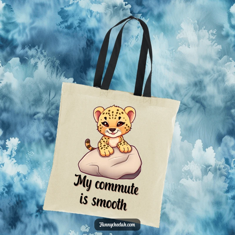 Funny tote bag showcasing a cheetah cub with a mischievous wink sliding down a smooth rock, ideal for carrying essentials with a bold spirit.
